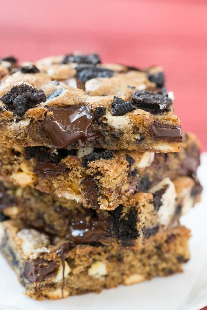 Cookies and Cream Bars Recipe | Oreo Bars | Blondie Recipe #chocolate #oreo #blondies #baking #cookies #jonep A stack of blondies filled with chocolate chunks and chopped cookies.