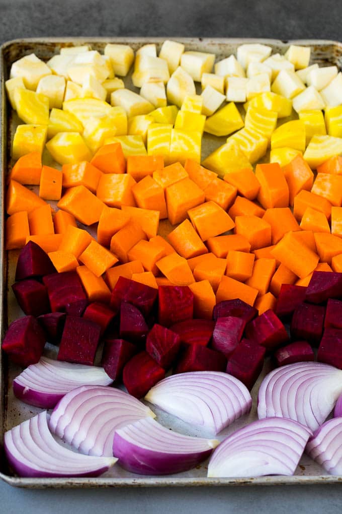 Roasted Root Vegetables Recipe | Roasted Sweet Potatoes | Roasted Beets | Roasted Carrots #carrots #beets #vegetables #sweetpotatoes #fall #parsnips #sidedish #jonep #cleaneating #healthy Onions, carrots, beets, parsnips and sweet potatoes on a sheet pan.