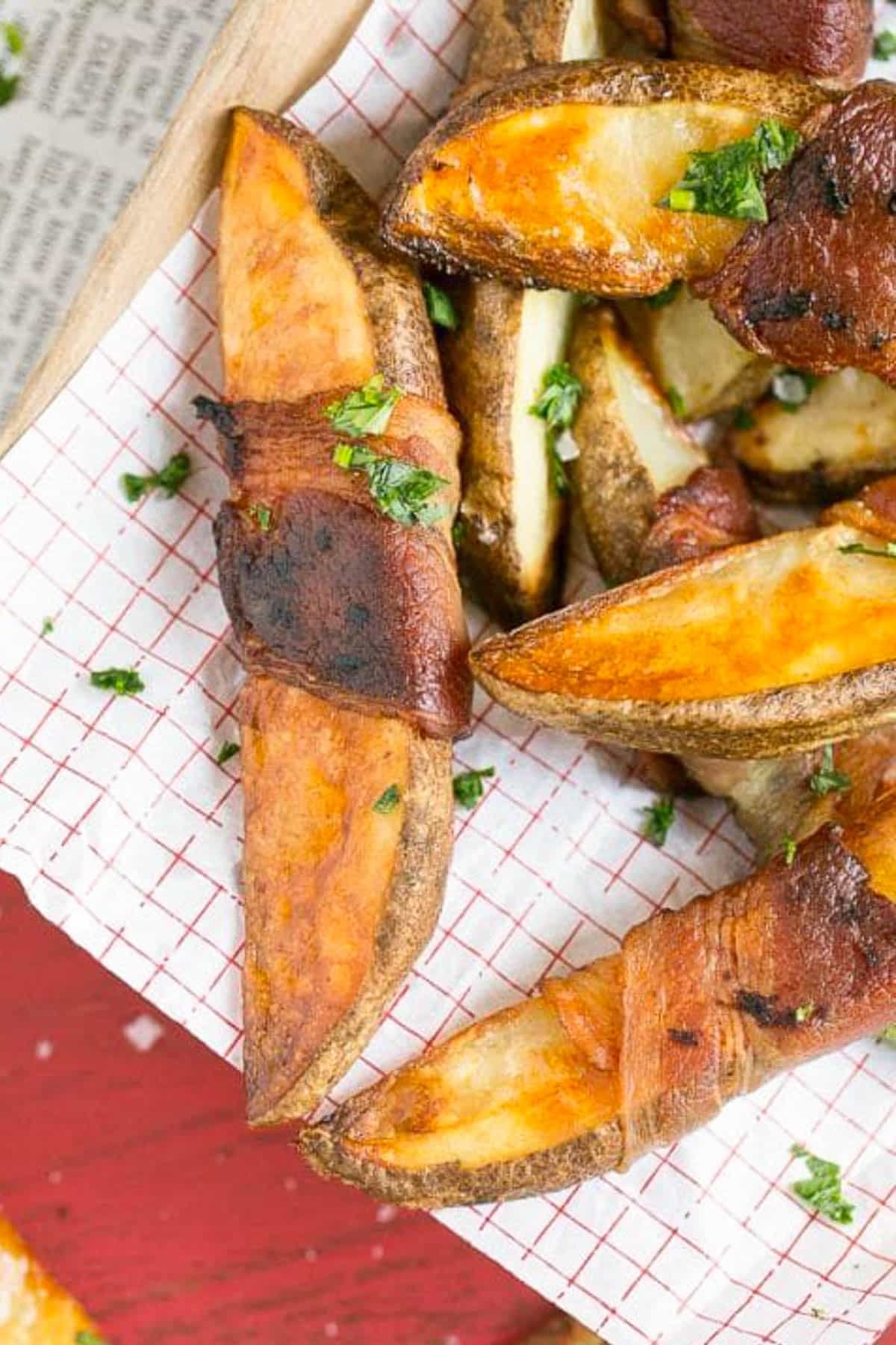 Bacon Wrapped Potato Wedges Recipe | Best Potato Wedges | Bacon Wrapped French Fries | Bacon Potato Wedges #bacon #potato #fries #dinner #jonep Bacon wrapped potatoes on a serving tray, topped with parsley.