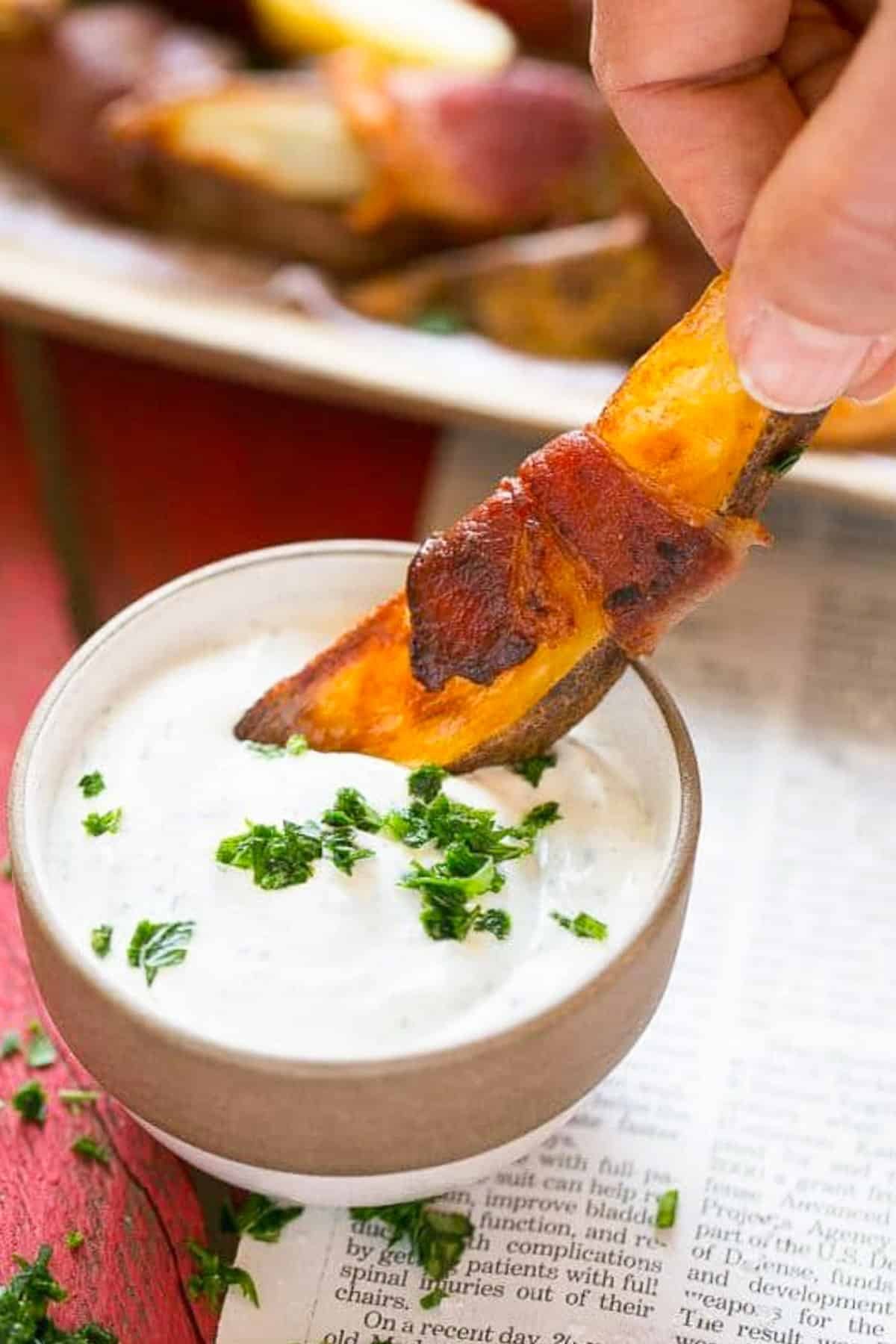 Bacon Wrapped Potato Wedges Recipe | Best Potato Wedges | Bacon Wrapped French Fries | Bacon Potato Wedges #bacon #potato #fries #dinner #jonep A hand putting bacon wrapped potatoes into ranch dip.