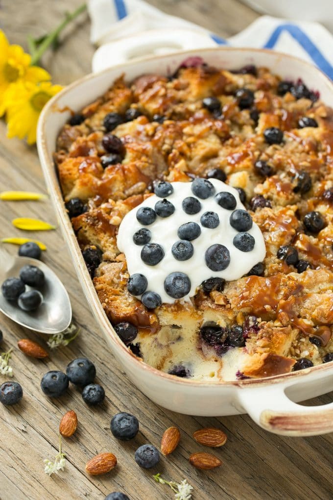 Blueberry Bread Pudding Recipe | Blueberry Bread Pudding | Easy Bread Pudding #blueberry #breadpudding #dessert #jonep A pan of blueberry bread pudding topped with streusel and caramel sauce.