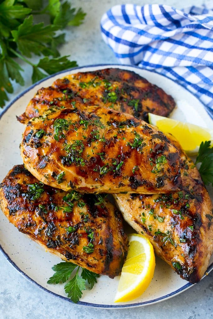 Grilled Chicken Breast Recipe | Marinated Chicken Breast | Chicken Marinade #chicken #grilling #marinade #summer #dinner #jonep A platter of grilled chicken breast served with parsley and lemon.