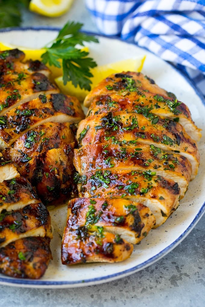Grilled Chicken Breast Recipe | Marinated Chicken Breast | Chicken Marinade #chicken #grilling #marinade #summer #dinner #jonep Sliced grilled chicken breast garnished with herbs and lemon.