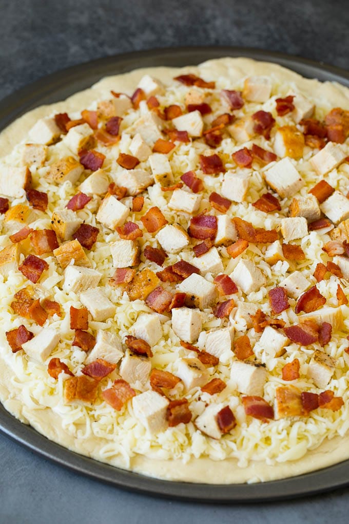 Chicken Alfredo Pizza Recipe #pizza #chicken #bacon #dinner #jonep A crust topped with sauce, shredded cheese and meat.