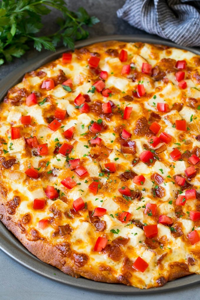 Chicken Alfredo Pizza Recipe #pizza #chicken #bacon #dinner #jonep A pizza topped with chicken, bacon, tomatoes and parsley.