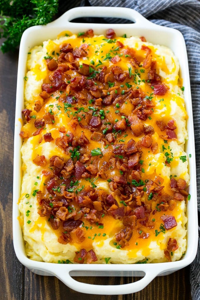 Loaded Mashed Potato Casserole Recipe | Loaded Potatoes | Bacon Mashed Potatoes | Thanksgiving Mashed Potatoes #potatoes #bacon #cheese #casserole #Thanksgiving #dinner #jonep Loaded mashed potato casserole topped with melted cheese, bacon and herbs.