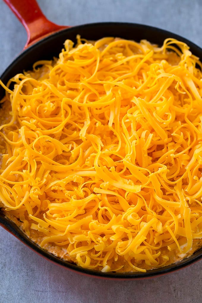 Buffalo Ranch Chicken Dip | Buffalo Chicken Dip | Baked Buffalo Dip | Cheesy Buffalo Dip #buffalowings #buffalochicken #dip #lowcarb #appetizer #jonep Buffalo chicken dip topped with shredded cheddar cheese, ready to go into the oven.