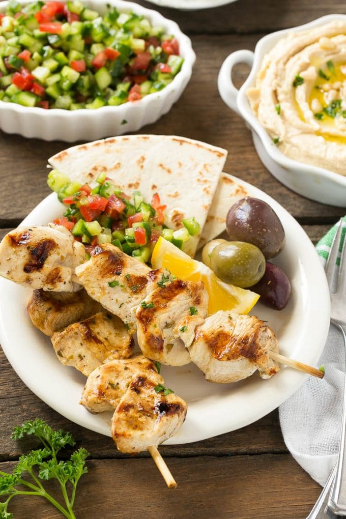 Greek Chicken Souvlaki Recipe | Easy Greek Chicken | Chicken Souvlaki | Greek Chicken Skewers | Easy Greek Chicken Skewers #chicken #kabobs #glutenfree #keto #lowcarb #grilling #jonep A plate of skewers with olives and pita bread.