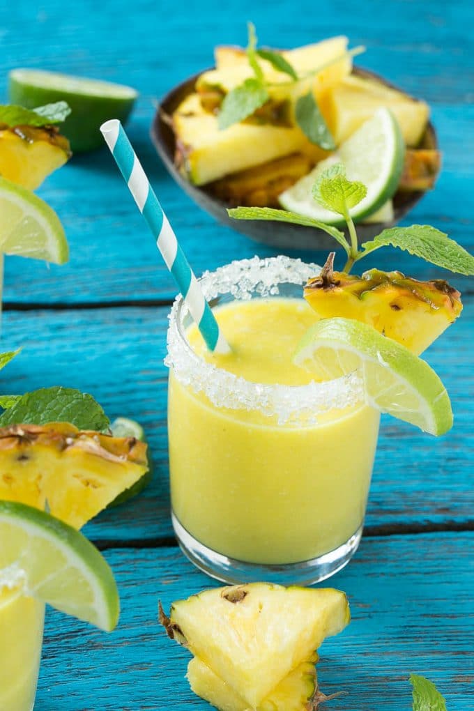Pineapple Coconut Smoothie Recipe |Tropical Smoothie | Pineapple Smoothie #smoothie #pineapple #coconut #healthy #cleaneating #jonep A tropical smoothie with a paper straw in it.
