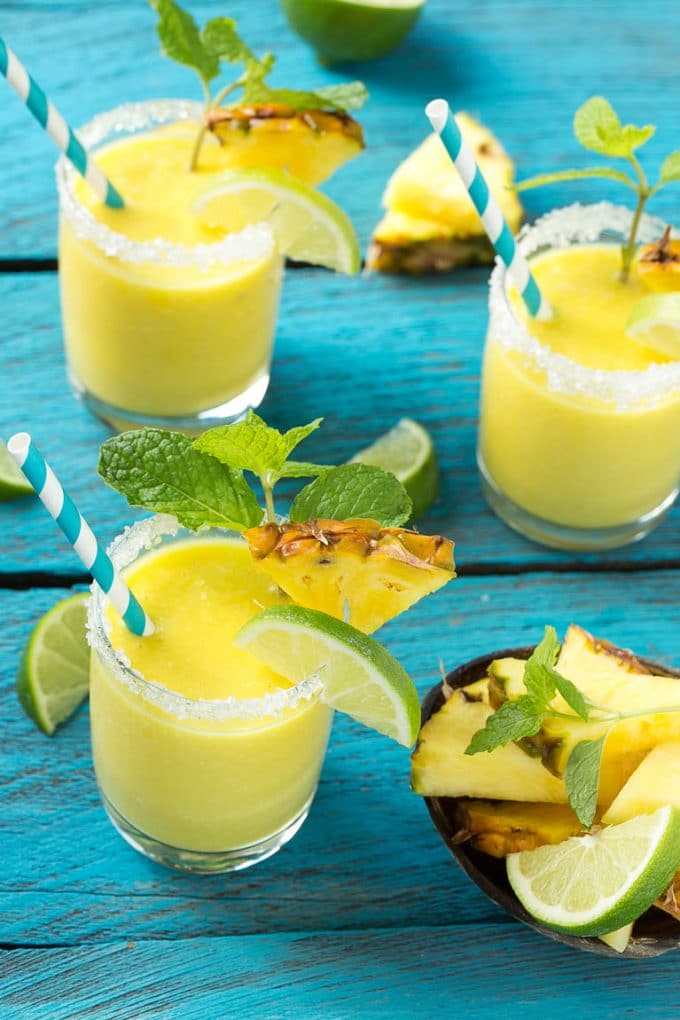 Pineapple Coconut Smoothie Recipe |Tropical Smoothie | Pineapple Smoothie #smoothie #pineapple #coconut #healthy #cleaneating #jonep Pineapple coconut smoothies in glasses with sugared rims.