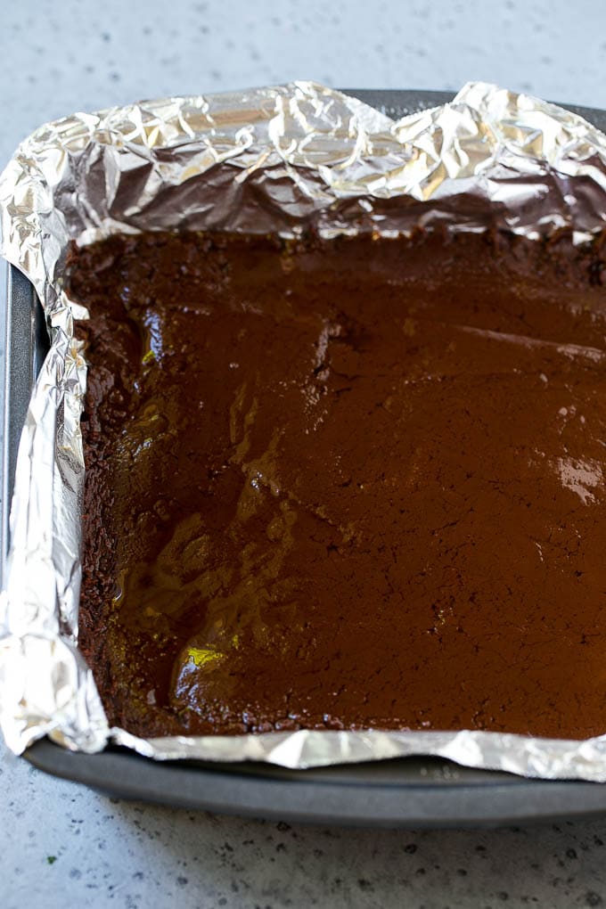 Chocolate Peanut Butter Fudge Recipe | Peanut Butter Cup Fudge | Easy Fudge Recipe #chocolate #peanutbutter #fudge #baking #dessert #jonep A layer of chocolate fudge in a pan.