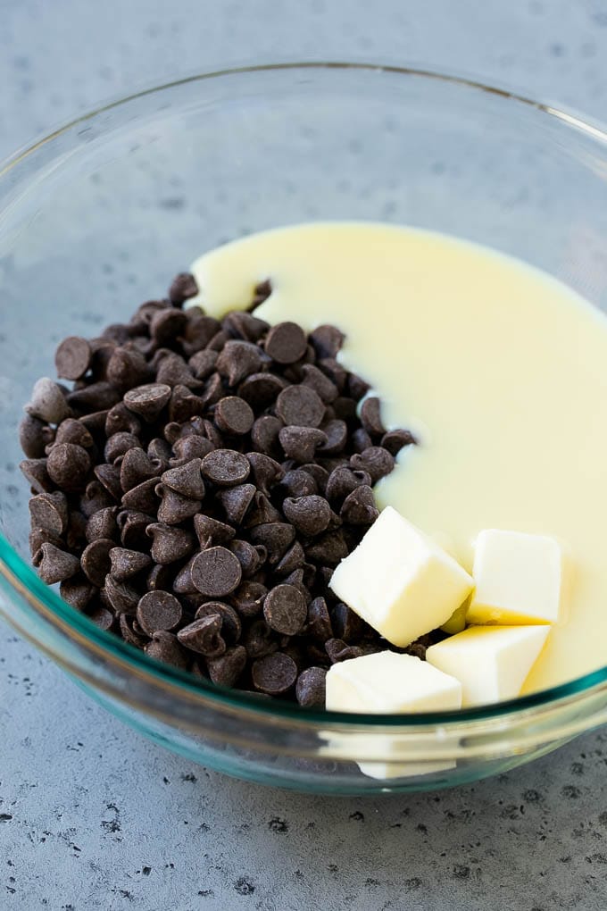 Chocolate Peanut Butter Fudge Recipe | Peanut Butter Cup Fudge | Easy Fudge Recipe #chocolate #peanutbutter #fudge #baking #dessert #jonep Chocolate chips, condensed milk and butter in a mixing bowl.