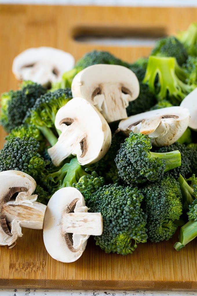 Chicken and Broccoli Stir Fry Recipe | Chicken Stir Fry | Healthy Chicken Recipe | Chicken and Broccoli | Chinese Food #chicken #broccoli #stirfry #healthy #cleaneating #dinner #jonep Broccoli florets and sliced mushrooms on a cutting board.
