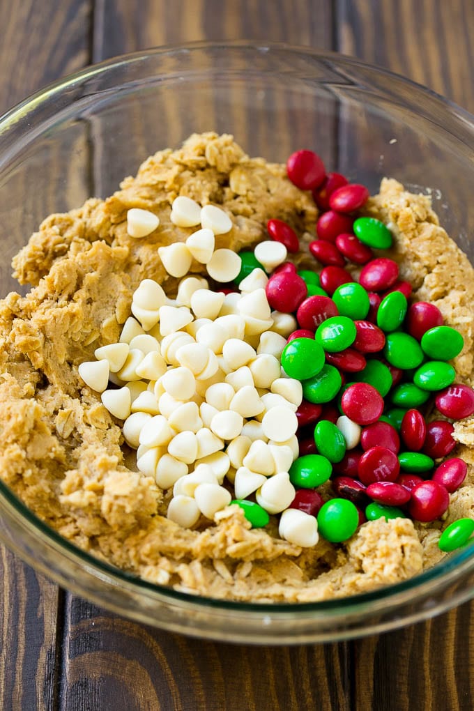 Christmas Monster Cookies Recipe | Oatmeal Cookies | Peanut Butter Cookies | M&M's Cookies #baking #cookies #dessert #peanutbutter #chocolate #jonep #christmas #sprinkles Cookie dough with red and green M&M's and white chocolate chips.