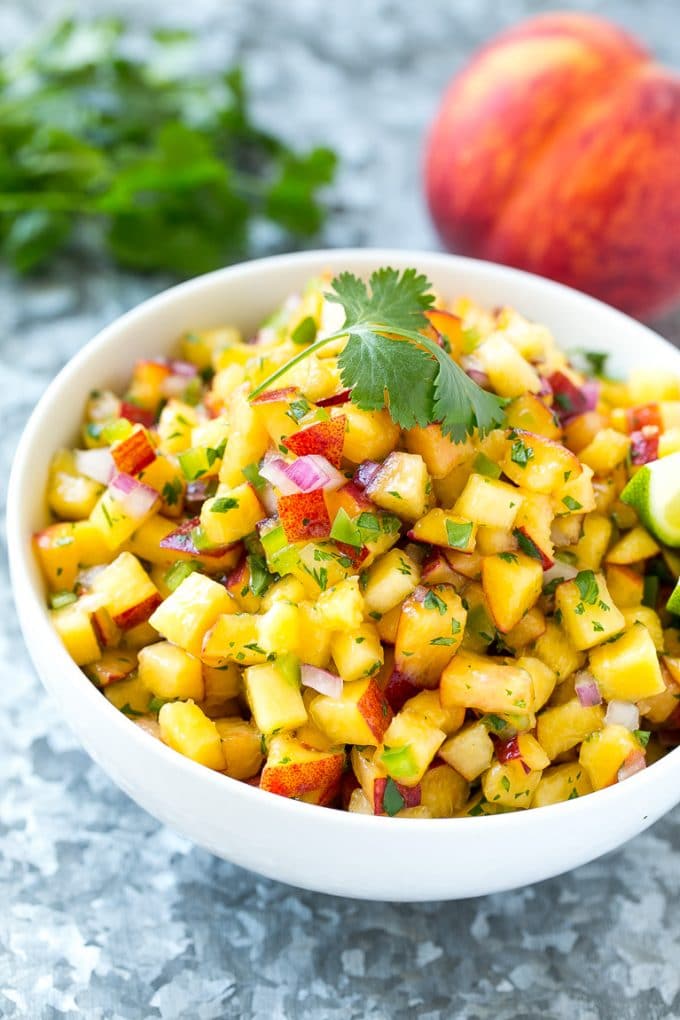 Peach Salsa | Fruit Salsa #peaches #salsa #dip #appetizer #jonep Peach salsa in a bowl made with red onion, jalapeno and cilantro.