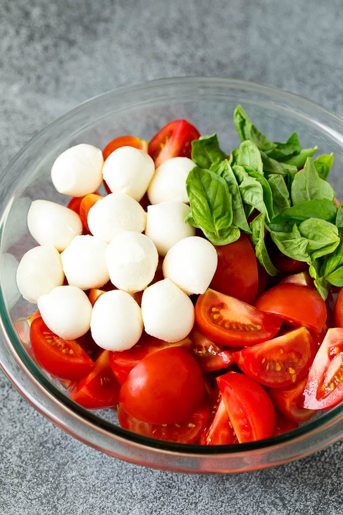 Caprese Salad Recipe | Tomato Salad #salad #tomato #mozzarella #cheese #basil #caprese #summer #jonep Tomatoes, mozzarella and basil in a bowl.