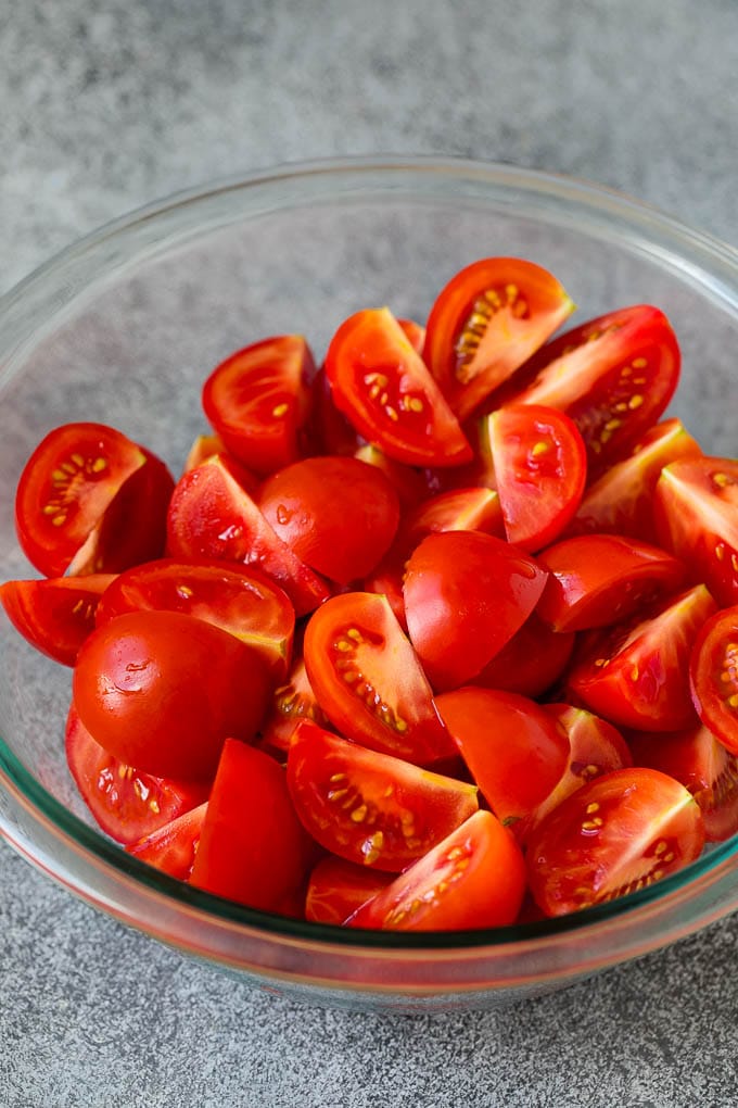 Caprese Salad Recipe | Tomato Salad #salad #tomato #mozzarella #cheese #basil #caprese #summer #jonep Quartered tomatoes in a bowl.