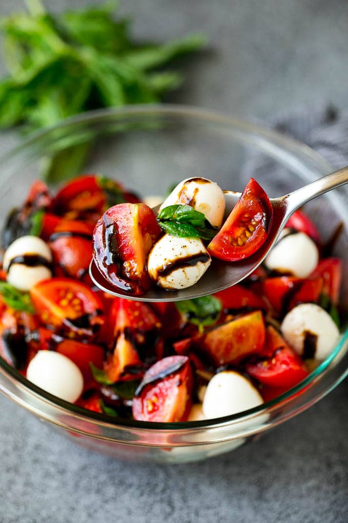 Caprese Salad Recipe | Tomato Salad #salad #tomato #mozzarella #cheese #basil #caprese #summer #jonep A serving spoon of caprese salad with tomato, mozzarella and basil.