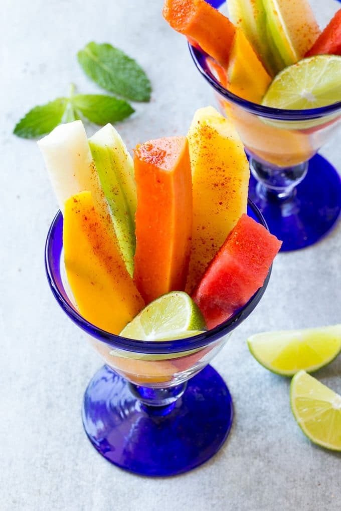 Mexican Fruit Cups | Fruit Cups | Mexican Fruit | Tropical Fruit #fruit #fruitcup #watermelon #pineapple #snack #healthy #jonep Spears of colorful fresh fruit, cucumbers and jicama in Mexican fruit cups.