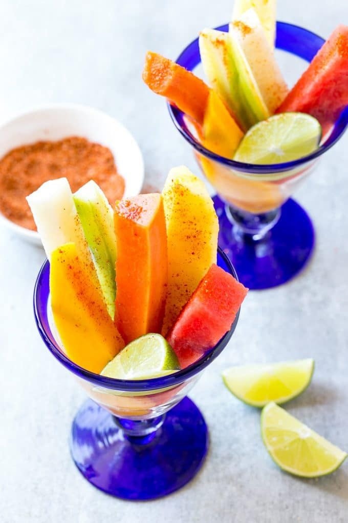 Mexican Fruit Cups | Fruit Cups | Mexican Fruit | Tropical Fruit #fruit #fruitcup #watermelon #pineapple #snack #healthy #jonep Spears of watermelon, cucumber, jicama, mango and pineapple in glasses.