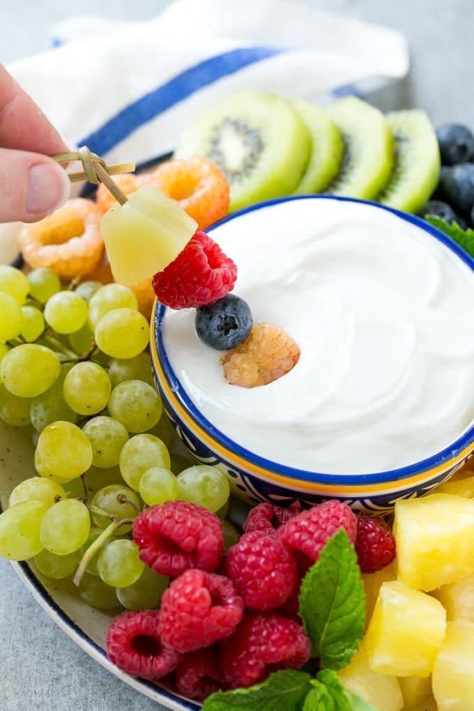 Cream Cheese Fruit Dip | Fruit Recipe | Fruit Dip #fruit #dip #creamcheese #snack #dessert #jonep A skewer of berries going into a bowl of fruit dip.