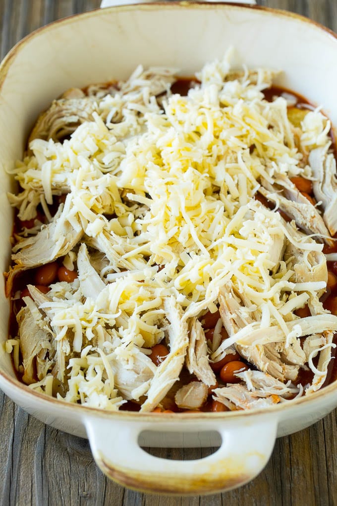 Chicken Enchilada Casserole Recipe | Chicken Enchiladas | Easy Casserole Recipe | Enchilada Casserole #chicken #casserole #enchiladas #cheese #beans #dinner #jonep Chicken, beans and shredded cheeses in a casserole dish.