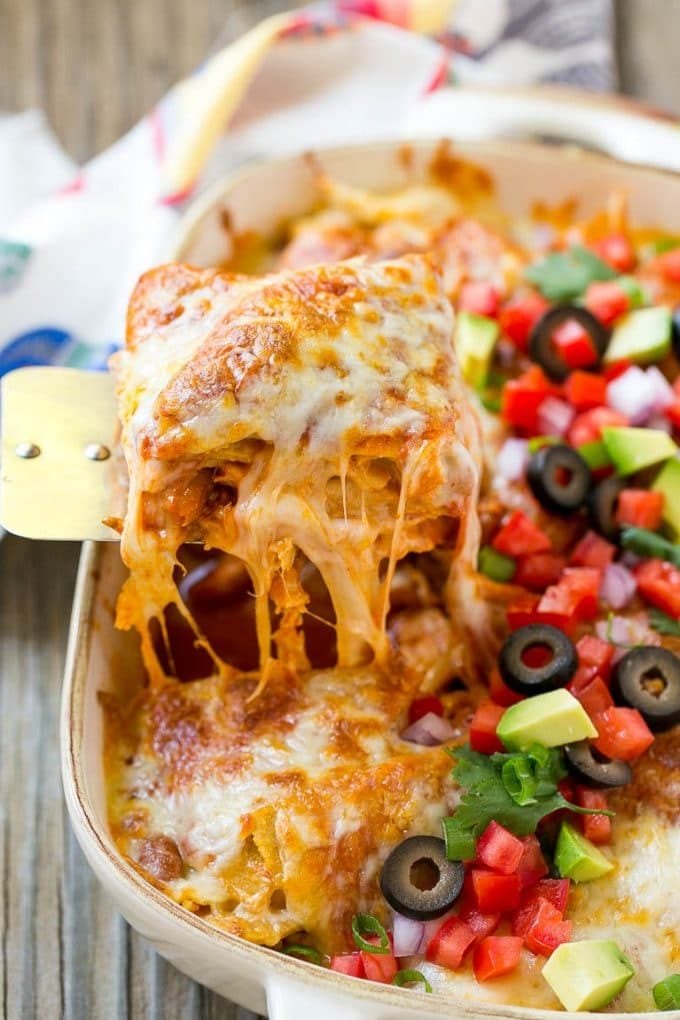Chicken Enchilada Casserole Recipe | Chicken Enchiladas | Easy Casserole Recipe | Enchilada Casserole #chicken #casserole #enchiladas #cheese #beans #dinner #jonep A spatula serving up a portion of cheesy chicken enchilada casserole.