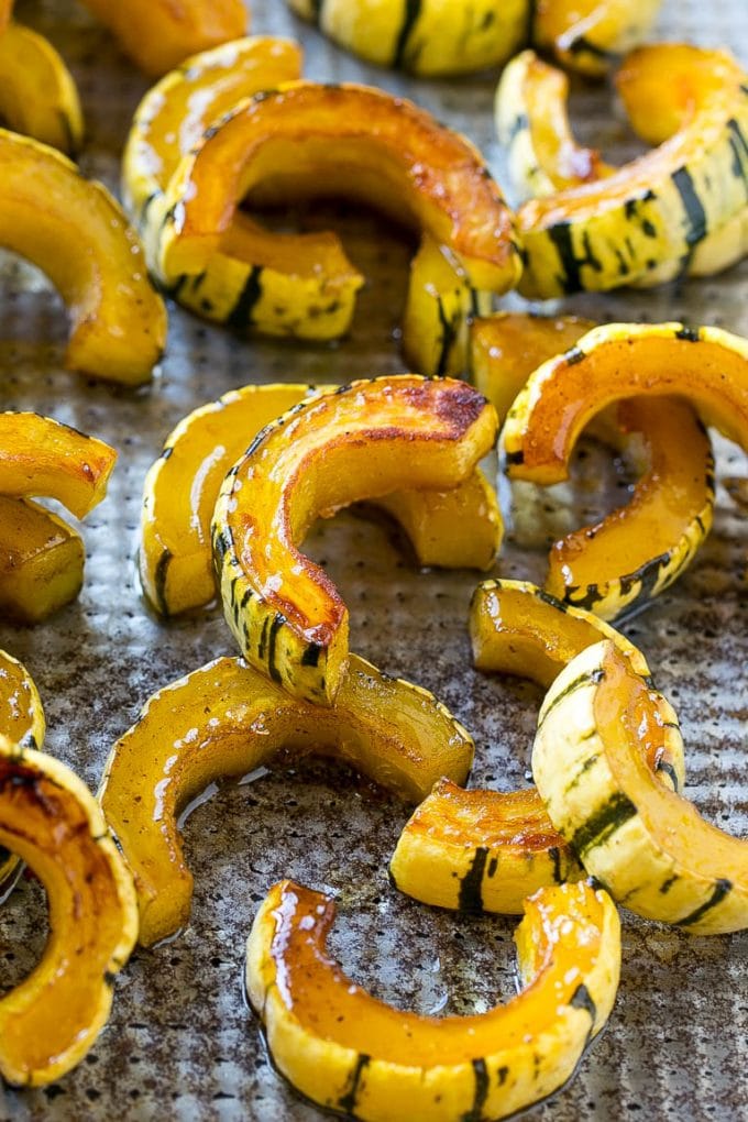 Brown Sugar Delicata Squash Recipe | Roasted Squash | Delicata Squash | Winter Squash Recipe #squash #wintersquash #brownsugar #sidedish #delicatasquash #dinner #jonep Roasted delicata squash on a sheet pan seasoned with brown sugar.