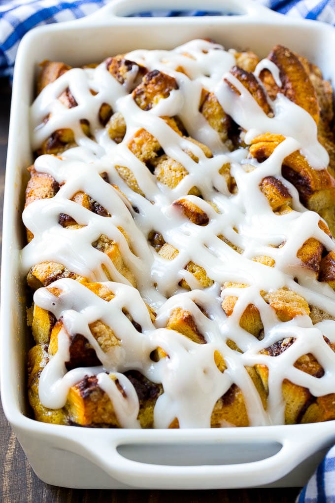 Cinnamon Roll French Toast Casserole | Cinnamon Roll French Toast Bake | Cinnamon Roll French Toast | Cinnamon French Toast #casserole #frenchtoast #cinnamonrolls #breakfast #jonep A cinnamon roll french toast casserole in a baking dish, topped with icing.