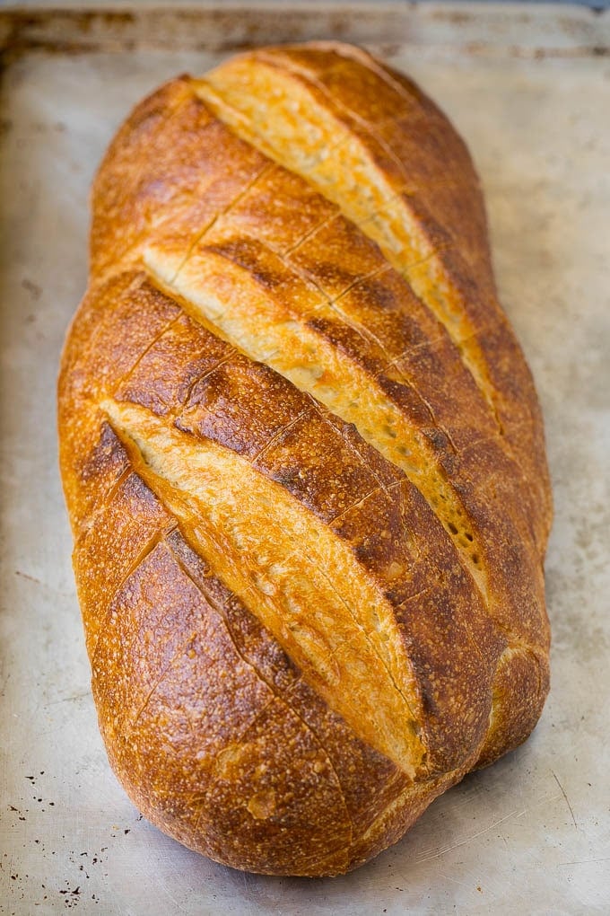 Pull Apart Bread | Garlic Bread | Cheese Bread #bread #garlic #cheese #sidedish #appetizer #jonep A loaf of bread on a sheet pan with diagonal cuts in it.