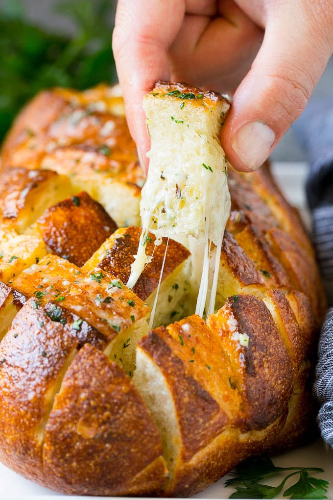 Pull Apart Bread | Garlic Bread | Cheese Bread #bread #garlic #cheese #sidedish #appetizer #jonep A hand grabbing a piece of pull apart bread.