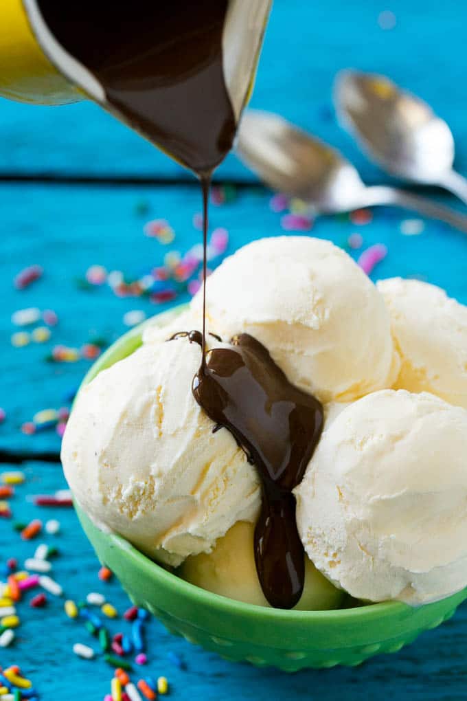 Homemade Magic Shell Recipe | Chocolate Ice Cream Topping | Chocolate Sauce | Hard Chocolate Coating #chocolate #icecream #dessert #jonep A pitcher of chocolate sauce being poured over vanilla ice cream.
