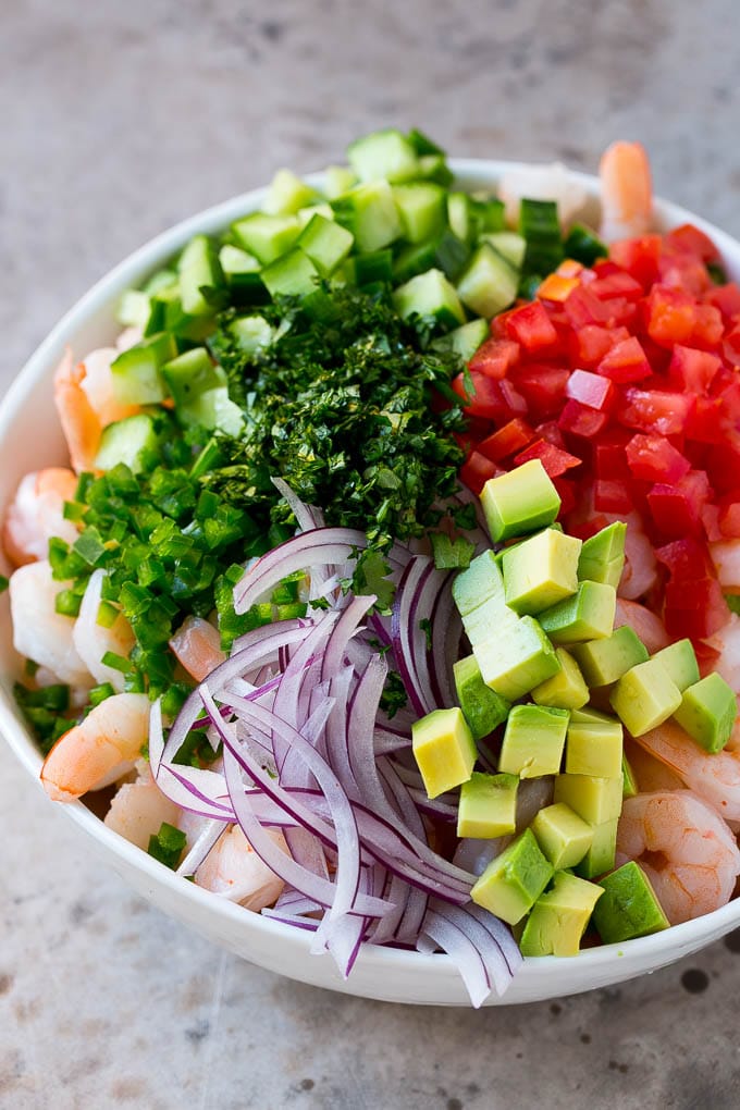 Shrimp Ceviche Recipe | Mexican Shrimp | Marinated Shrimp #shrimp #ceviche #cleaneating #healthy #lowcarb #keto #glutenfree #dinner #appetizer #jonep Prawns, avocado, red onion tomatoes, cilantro, jalapeno and cilantro in a bowl.
