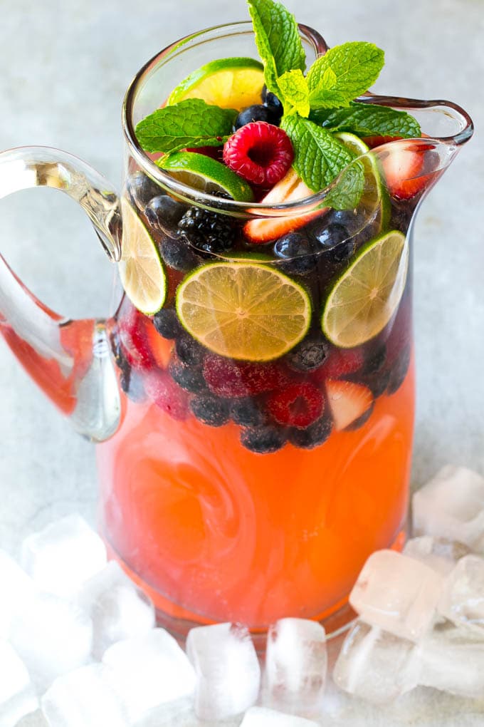 Berry Champagne Punch Recipe | Champagne Cocktail | Lime Cocktail | Berry Punch | Champagne Recipe #champagne #punch #berries #drink #jonep A pitcher of a cocktail garnished with fruit and mint.