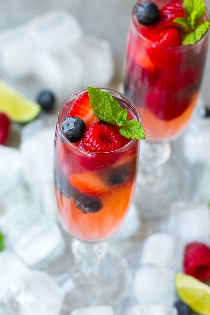 Berry Champagne Punch Recipe | Champagne Cocktail | Lime Cocktail | Berry Punch | Champagne Recipe #champagne #punch #berries #drink #jonep Two glasses of refreshing champagne punch with berries and mint on top.