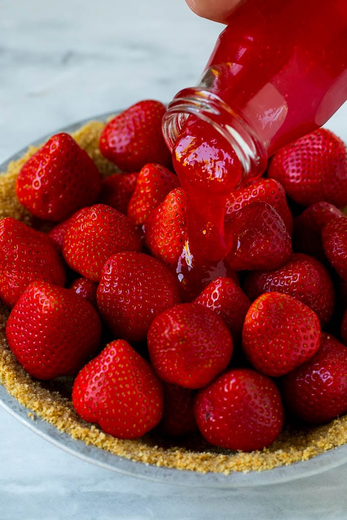No Bake Strawberry Pie Recipe | Fresh Strawberry Pie | Strawberry Pie Recipe | No Bake Pie Recipe #strawberry #strawberrypie #nobake #nobakepie #dessert #jonep Glaze being poured over a strawberry pie.