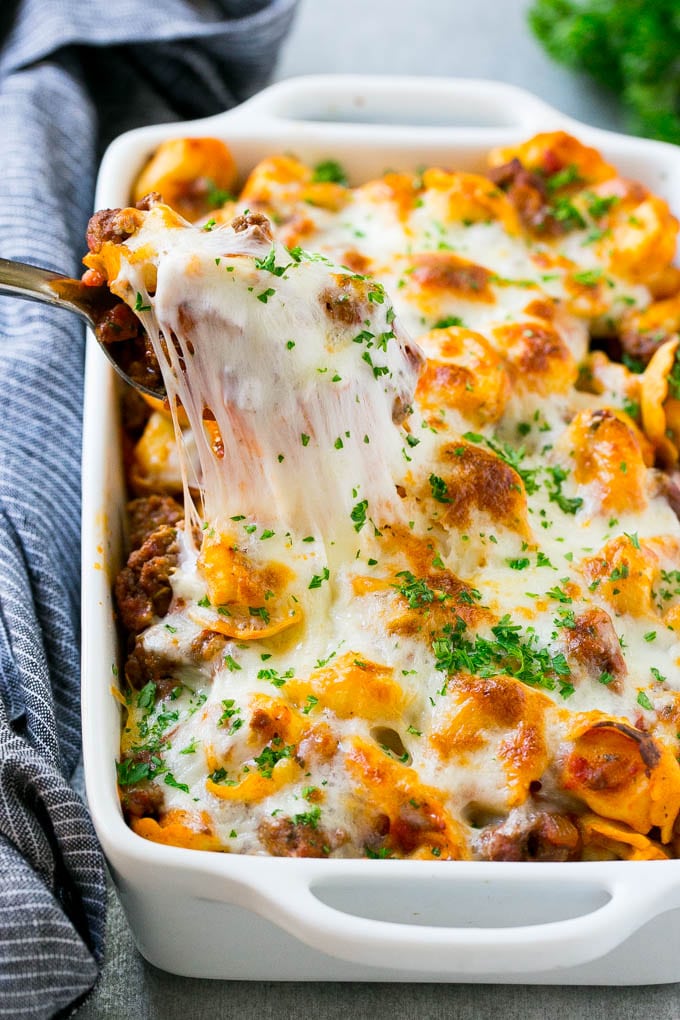 Baked Tortellini with Meat Sauce Recipe | Cheese Tortellini | Tortellini Recipe | Baked Pasta Recipe #tortellini #bakedtortellini #meatsauce #pasta #dinner #jonep A pan of cheesy baked tortellini with a spoon lifting up a portion.
