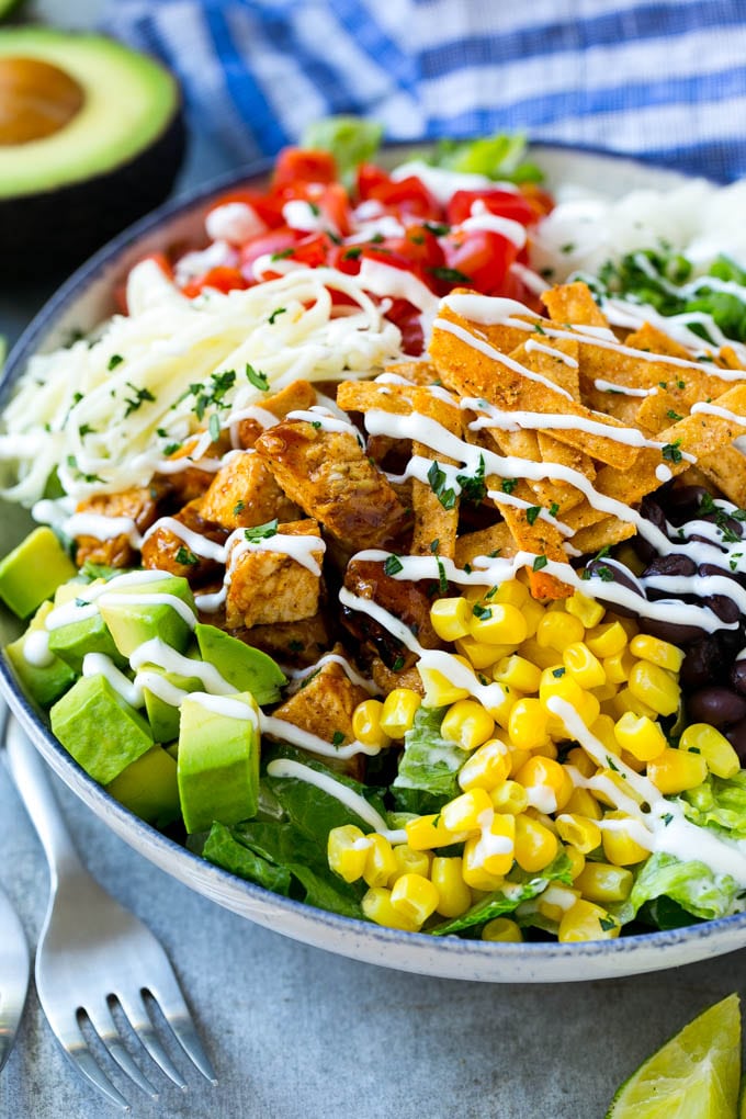 BBQ Chicken Salad Recipe | Chopped BBQ Chicken Salad | CPK Copycat Recipe | California Pizza Kitchen Copycat Recipe | Chicken Ranch Salad #copycat #CPK #BBQchicken #chicken #salad #dinner #jonep A bowl of BBQ chicken salad topped with a drizzle of ranch dressing.