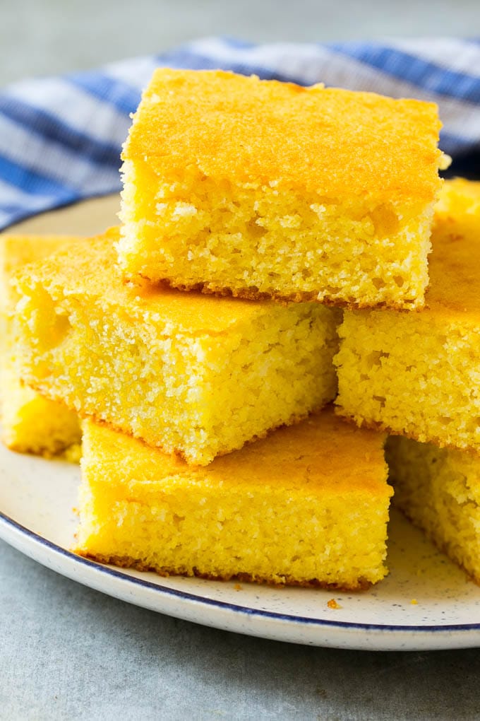Honey Cornbread Recipe | Buttermilk Cornbread | Easy Cornbread | Homemade Cornbread | Cast Iron Cornbread #cornbread #honey #buttermilk #bread #jonep A plate full of squares of bread made with cornmeal.