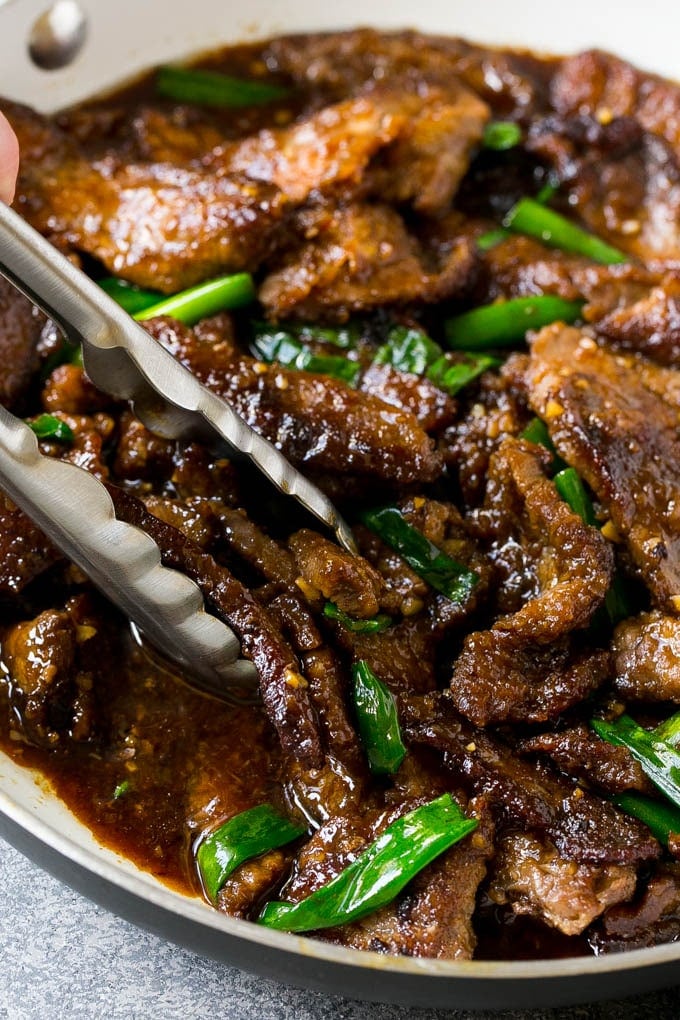 Mongolian Beef Recipe | Asian Beef Recipe | Chinese Beef | Beef Stir Fry #Chinese #Mongolian #Asian #mongolianbeef #beef #jonep #dinner A pan of Mongolian beef with tongs in it.