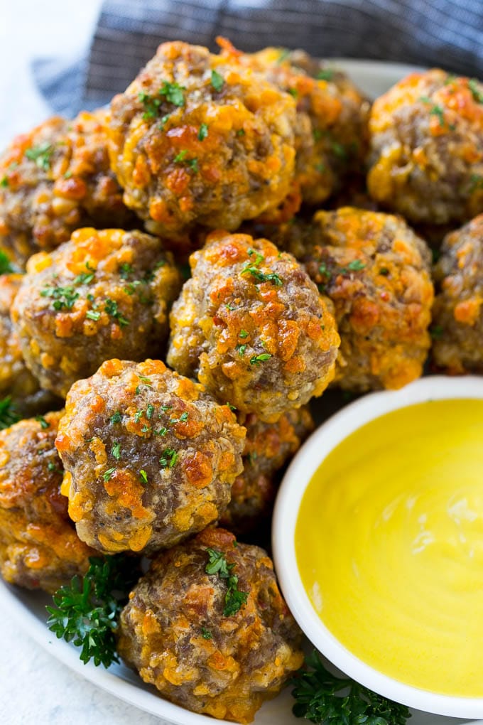 Sausage Cheese Balls Recipe | Sausage Balls Recipe | Bisquick Sausage Balls #sausage #sausageballs #balls #appetizer #cheeseballs #jonep A platter of sausage cheese balls with honey mustard sauce for dipping.