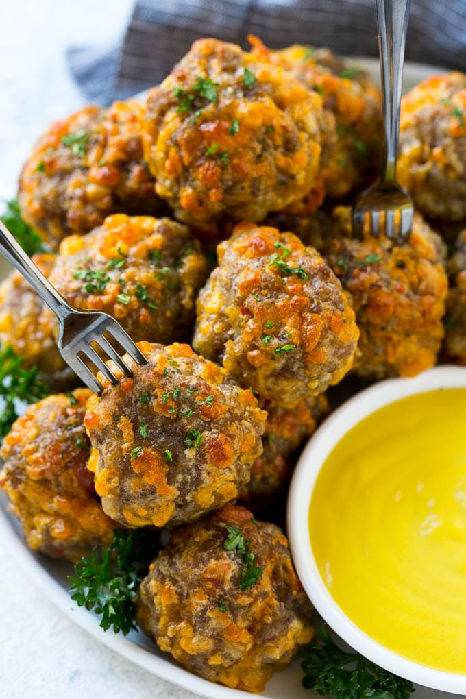Sausage Cheese Balls Recipe | Sausage Balls Recipe | Bisquick Sausage Balls #sausage #sausageballs #balls #appetizer #cheeseballs #jonep A plate of meatballs with cocktail forks.