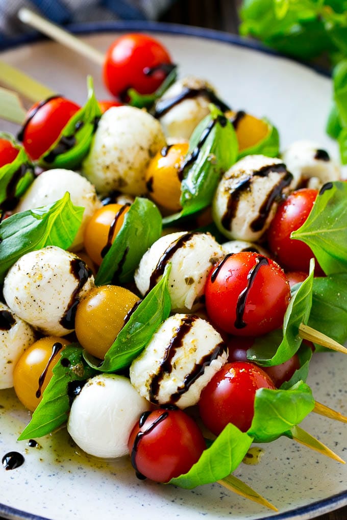 Caprese Skewers | Caprese Kabobs | Caprese Appetizer #tomato #mozzarella #basil #caprese #appetizer #jonep A plate of caprese skewers with mozzarella, tomatoes and basil.