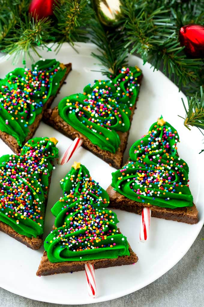 title="Christmas Tree Brownies | Christmas Brownies | Holiday Brownies | Christmas Tree Dessert #brownies #dessert #christmas #holiday #dessert #jonep" Christmas Brownies topped with frosting and rainbow sprinkles on a plate.