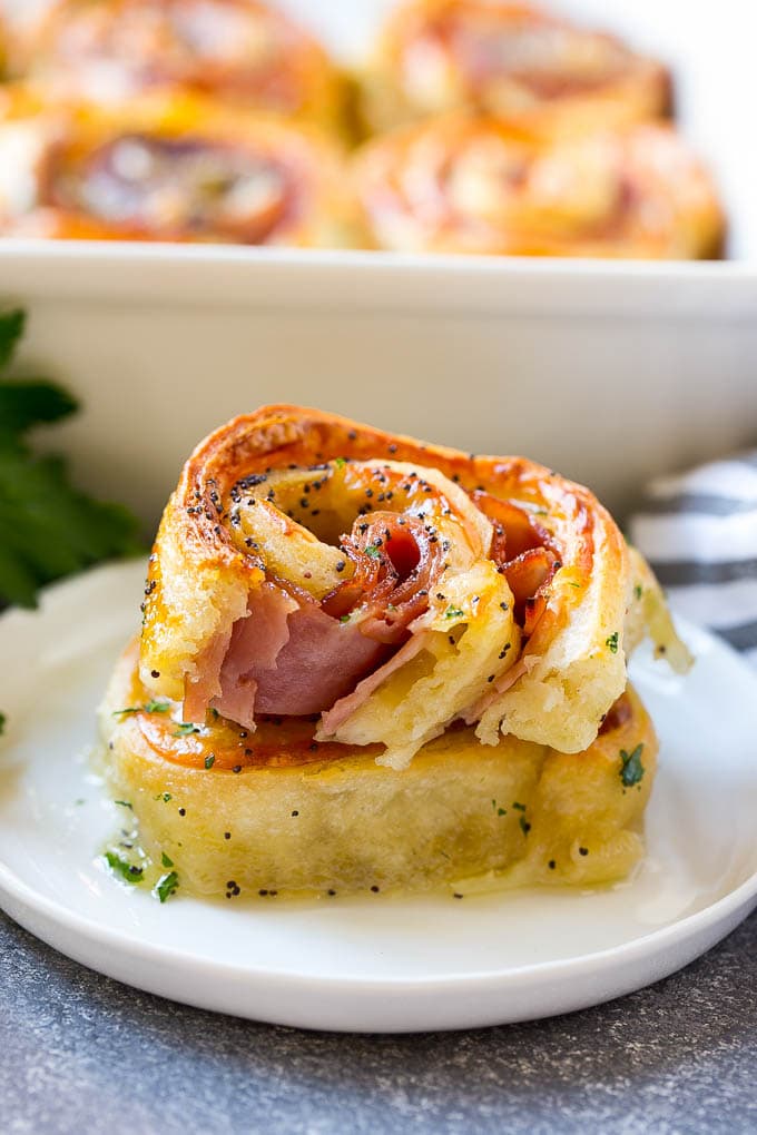 Ham and Cheese Pinwheels Recipe | Ham and Cheese Roll Ups | Ham and Cheese Rolls | Ham and Cheese Bread Rolls #ham #cheese #appetizer #pinwheels #jonep Ham and cheese pinwheels stacked on a serving plate.