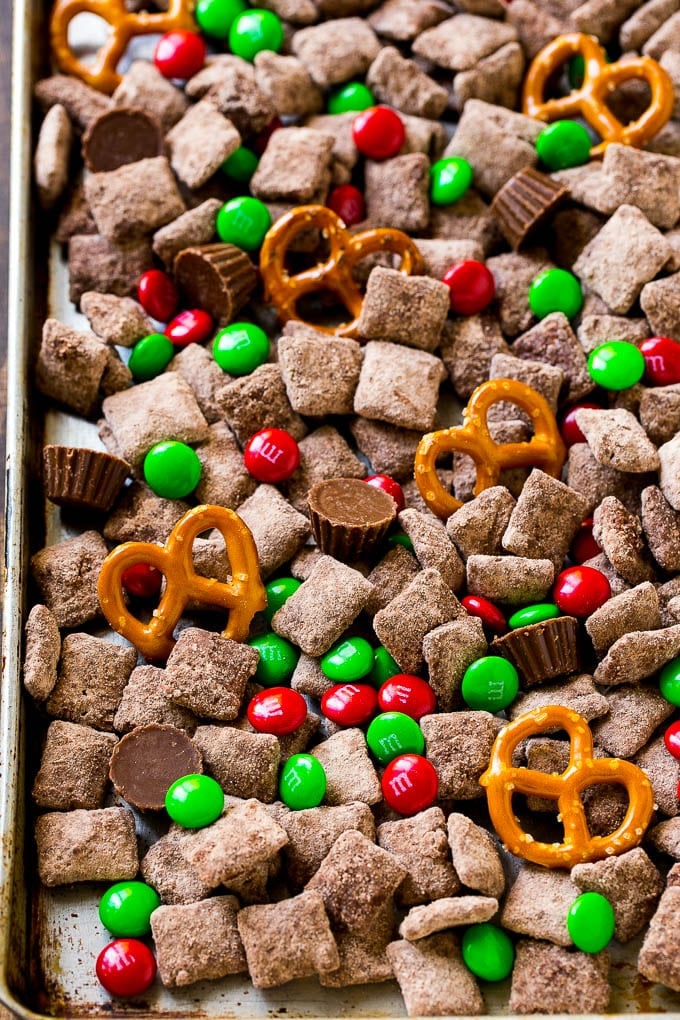 Reindeer Chow | Christmas Chex Mix | Christmas Muddy Buddies | Holiday Chex Mix #chex #chexmix #christmas #holiday #muddybuddies #reindeerchow #snack #jonep A sheet pan of Christmas muddy buddies mixed with candy and peanut butter cups.