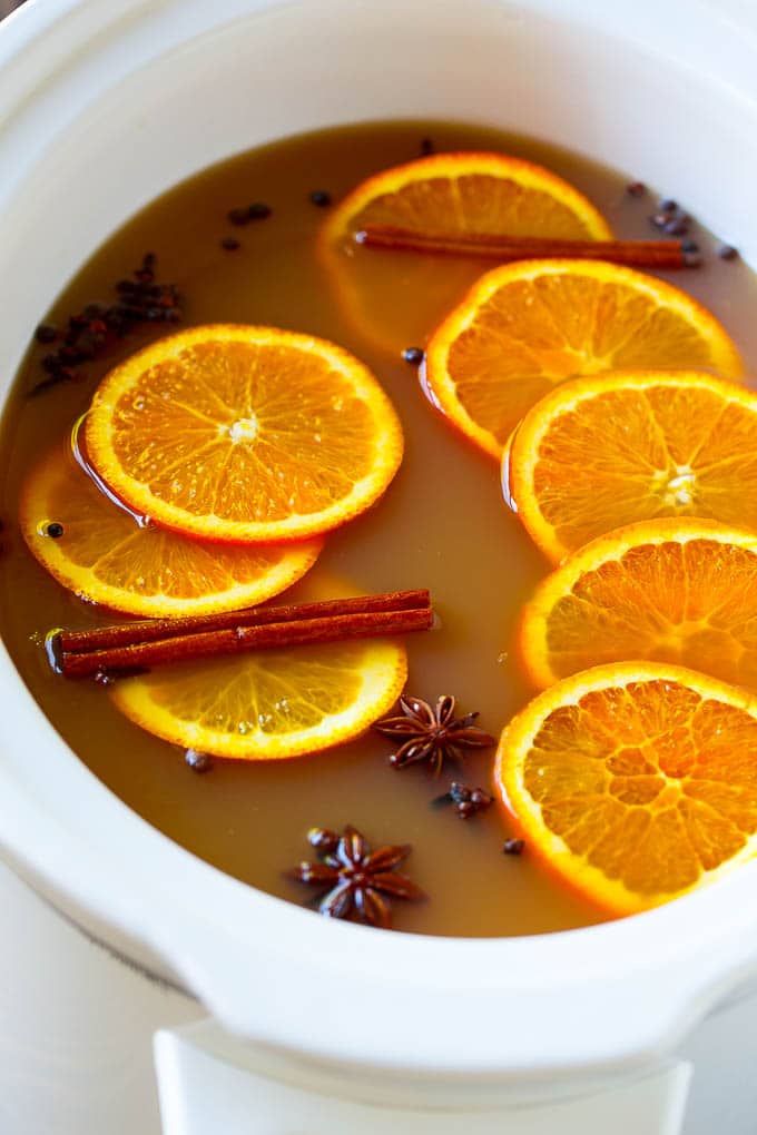 Slow Cooker Apple Cider | Mulled Apple Cider | Crockpot Apple Cider #cider #apple #applecider #drink #crockpot #slowcooker #jonep Crock pot spiced drink with orange slices and aromatic spices.