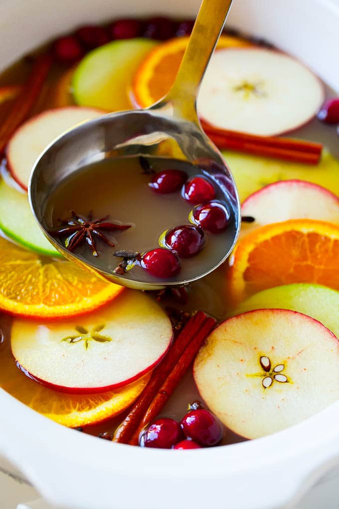 Slow Cooker Apple Cider | Mulled Apple Cider | Crockpot Apple Cider #cider #apple #applecider #drink #crockpot #slowcooker #jonep A ladle scooping out some warm mulled drink.