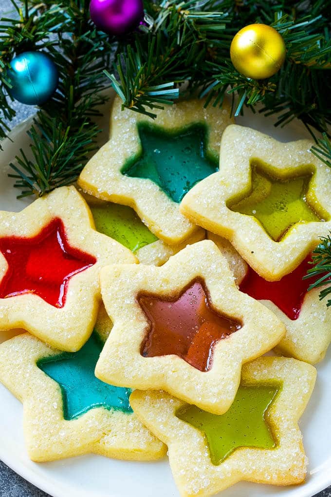 Stained Glass Cookies | Stained Glass Window Cookies | Christmas Cookies | Sugar Cookies | Holiday Cookies #cookies #stainedglasscookies #sugarcookies #christmascookies #christmas #holiday #dessert #jonep A plate of star shaped stained glass cookies with colorful centers.