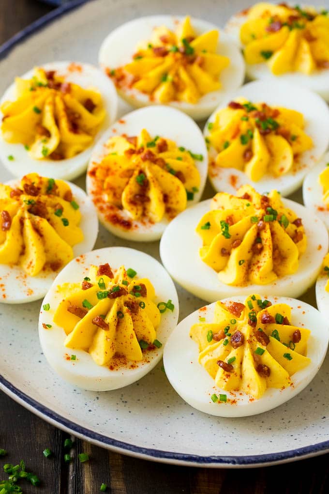 Bacon Deviled Eggs | Deviled Eggs Recipe #eggs #keto #lowcarb #bacon #appetizer #jonep A plate of bacon deviled eggs garnished with sliced chives and smoked paprika.